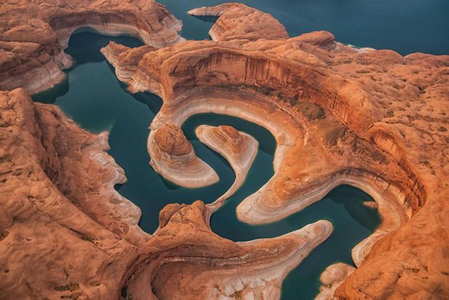 An overhead shot of a river wending through dramatic desert rock formations. 
