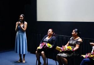 Young woman speaking to an audience in a panel after showing a film.