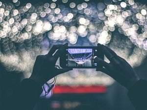 image of a phone taking a picture of a crowd at night 