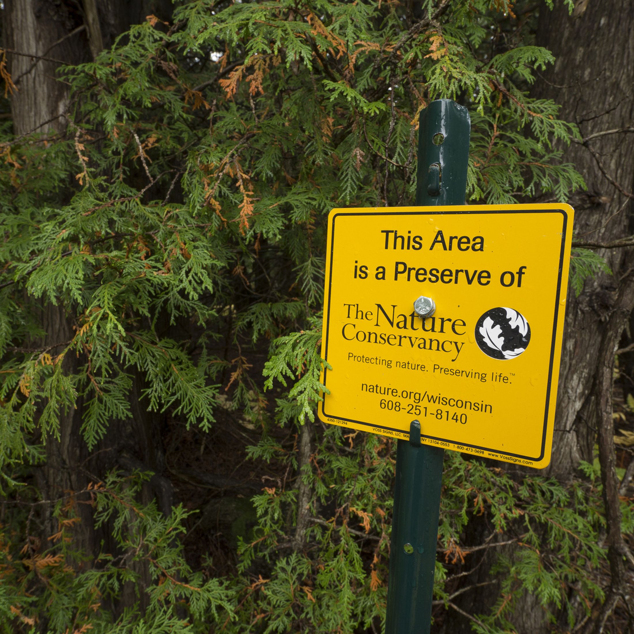 A sign that says this area is a preserve of The Nature Conservancy. Protecting nature. Preserving life. It also includes a vanity URL and a phone number.