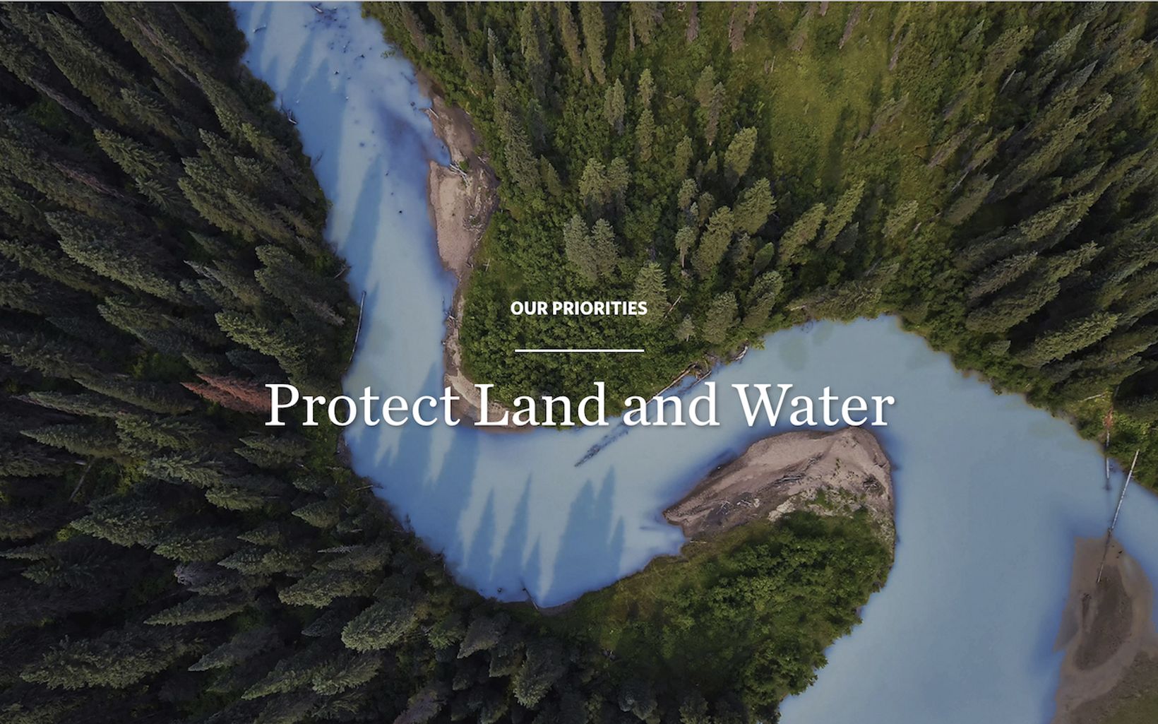 Aerial view of a river through a forests with navigational text: 'Our priorities, Protect land and water'.