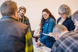People looking over a table. 