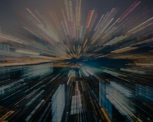 Zoomed-in city at night creates streaking effects.