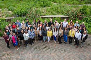 A large group of people gather together in a garden area at the TNC Arlington office.