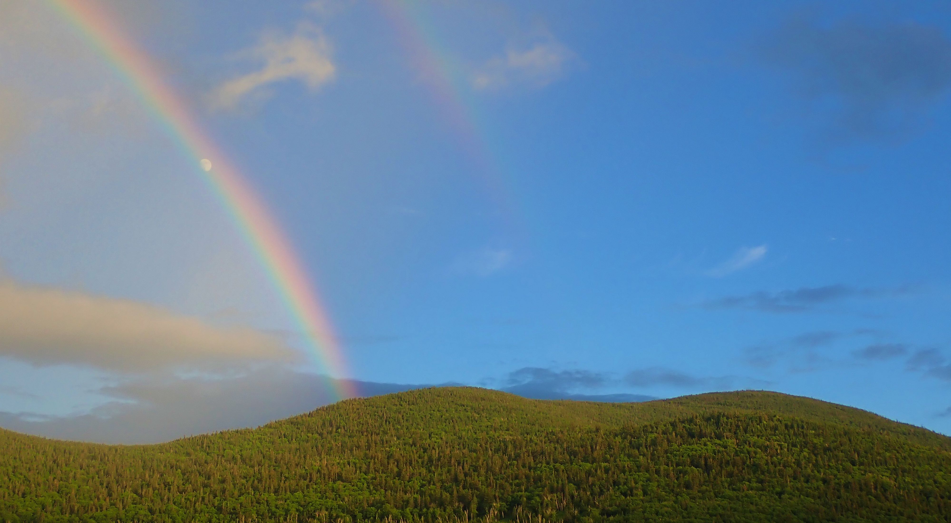 A rainbow arches over Caribou Mountain in the 9,608-acre newly-conserved forest.