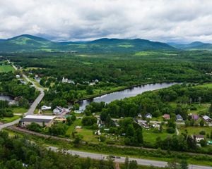 Aerial image of town, river and mountains.