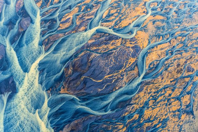 Brightly colored sediment paints the Icelandic landscape as at flows towards the ocean. The glacial river, Þjórsá, is the longest river in Iceland.