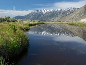 Snow-capped mountains reflected in the Carson River at River Fork Ranch.