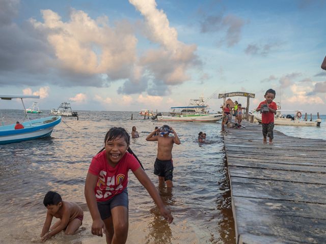 Niños juegan en la orilla cerca del muelle de Puerto Morelos.