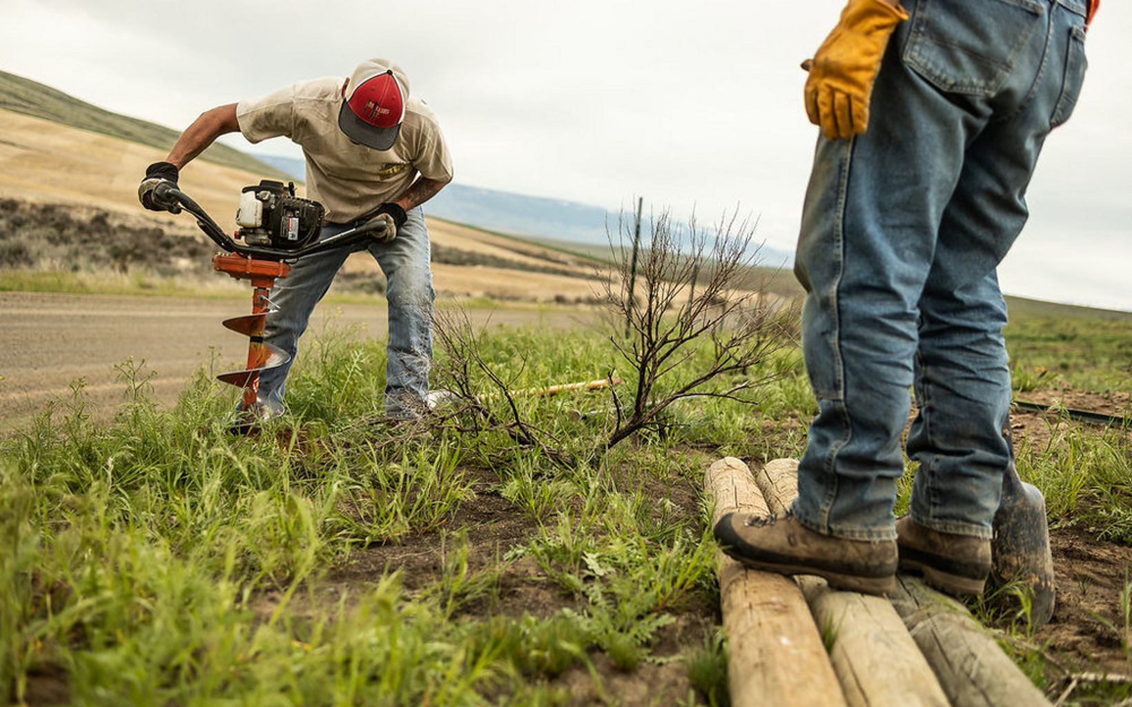 A man drills a hole for a fence post at TNC's Beezley Hills Preserve in Washington state.