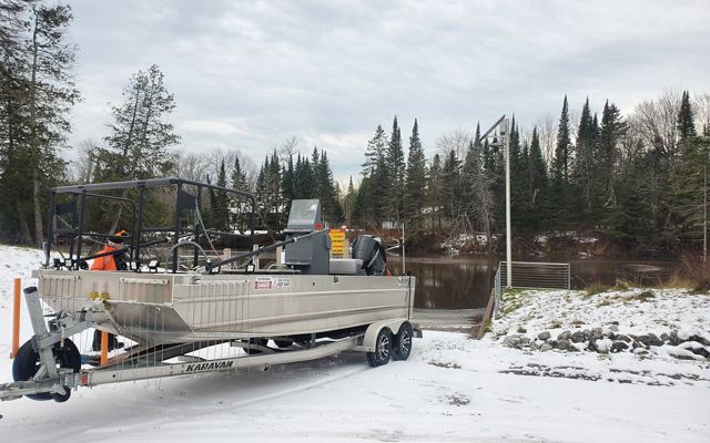 An electrofishing vessel prepares to be released in a Michigan river on a snowy day.