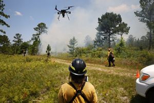 Fire crew member operating an aerial ignition drone.