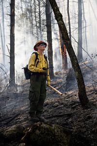 Burn crew member surrounded by a forest.