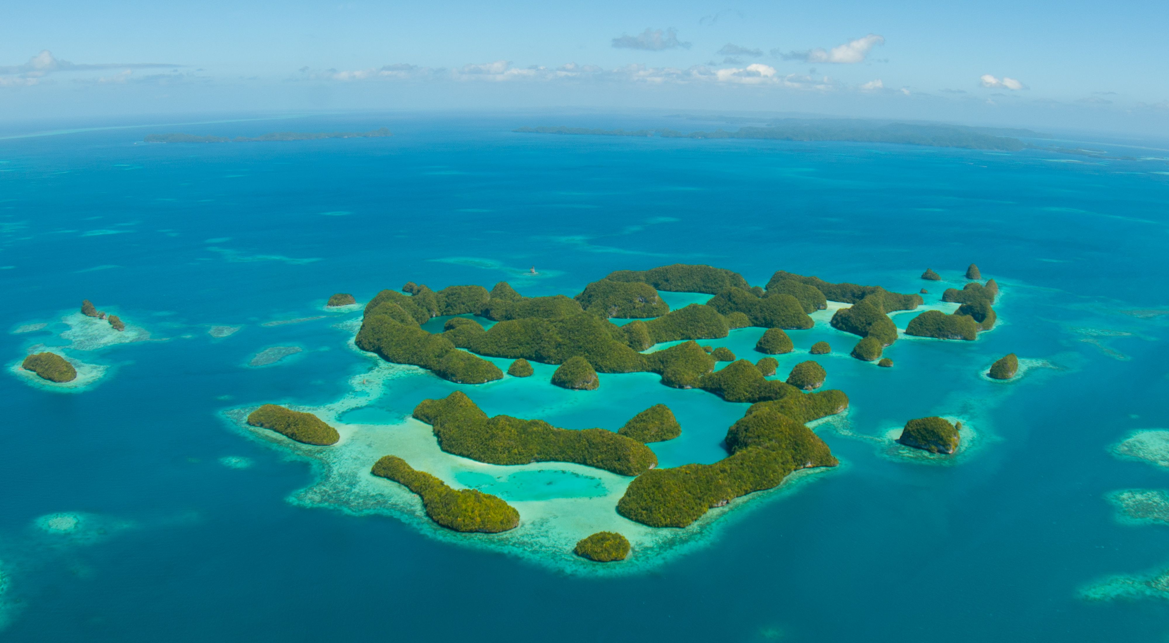 an aerial view of Palau's islands and aqua-blue ocean waters