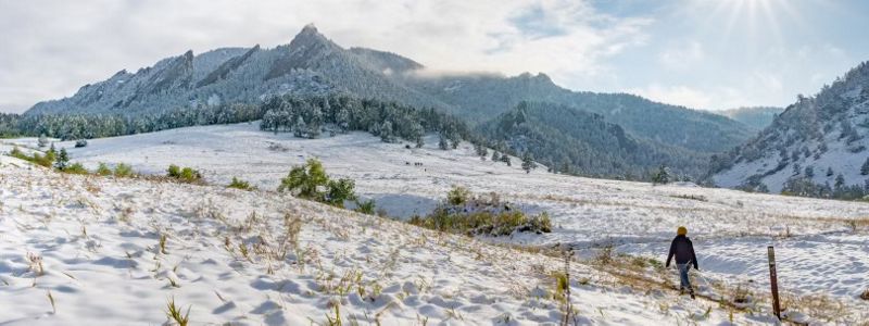 A field covered in snow with mountains in the background.