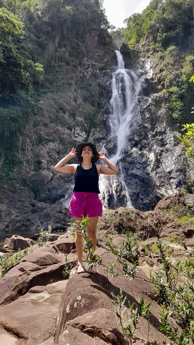 Diana Oviedo Vargas stands on rocks in front of a large waterfall.