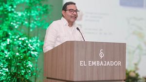 A man standing at podium speaks to a group.