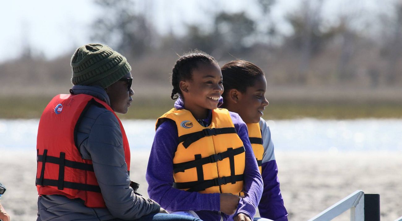 A mother and two girls enjoy a boat ride.