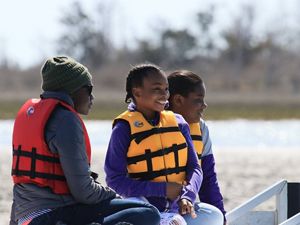 A family of three people enjoys a boat tour at Brownsville Preserve.