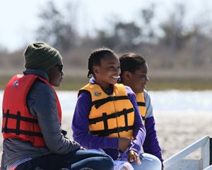 A family of three people enjoys a boat tour at Brownsville Preserve.