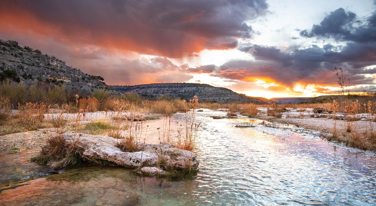 A rocky creek runs through a dry landscape.