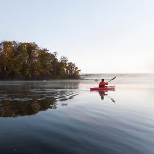 A kayaker on a calm river.