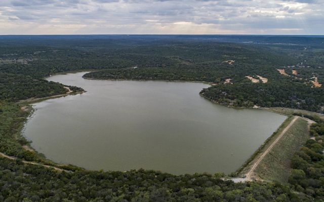 Vista aérea de un lago rodeado por bosques verdes. 