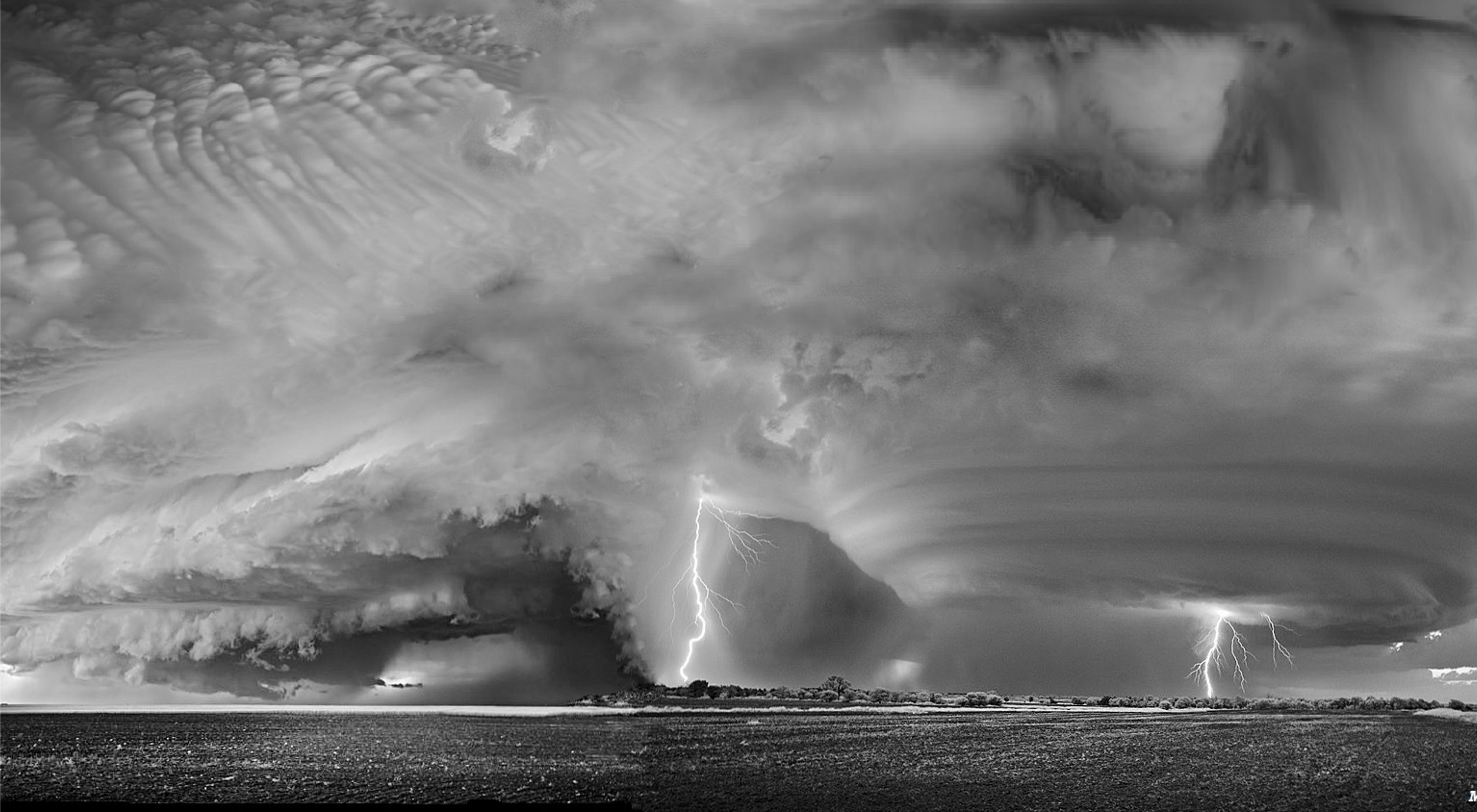 Lightning strikes from a massive swirling stormcloud 