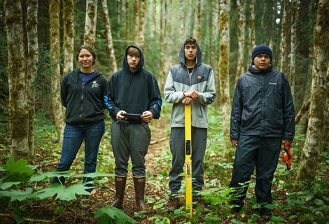 A group of youth standing in a forest.