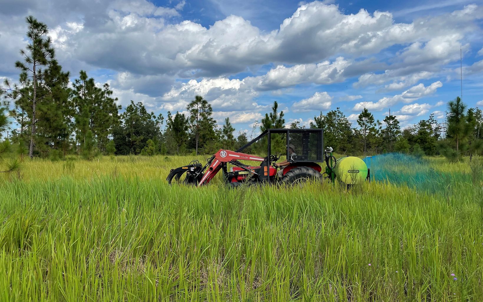Non-native cogon grass is sprayed on nearby partner lands by a tractor at Apalachicola Bluffs and Ravines Preserve.