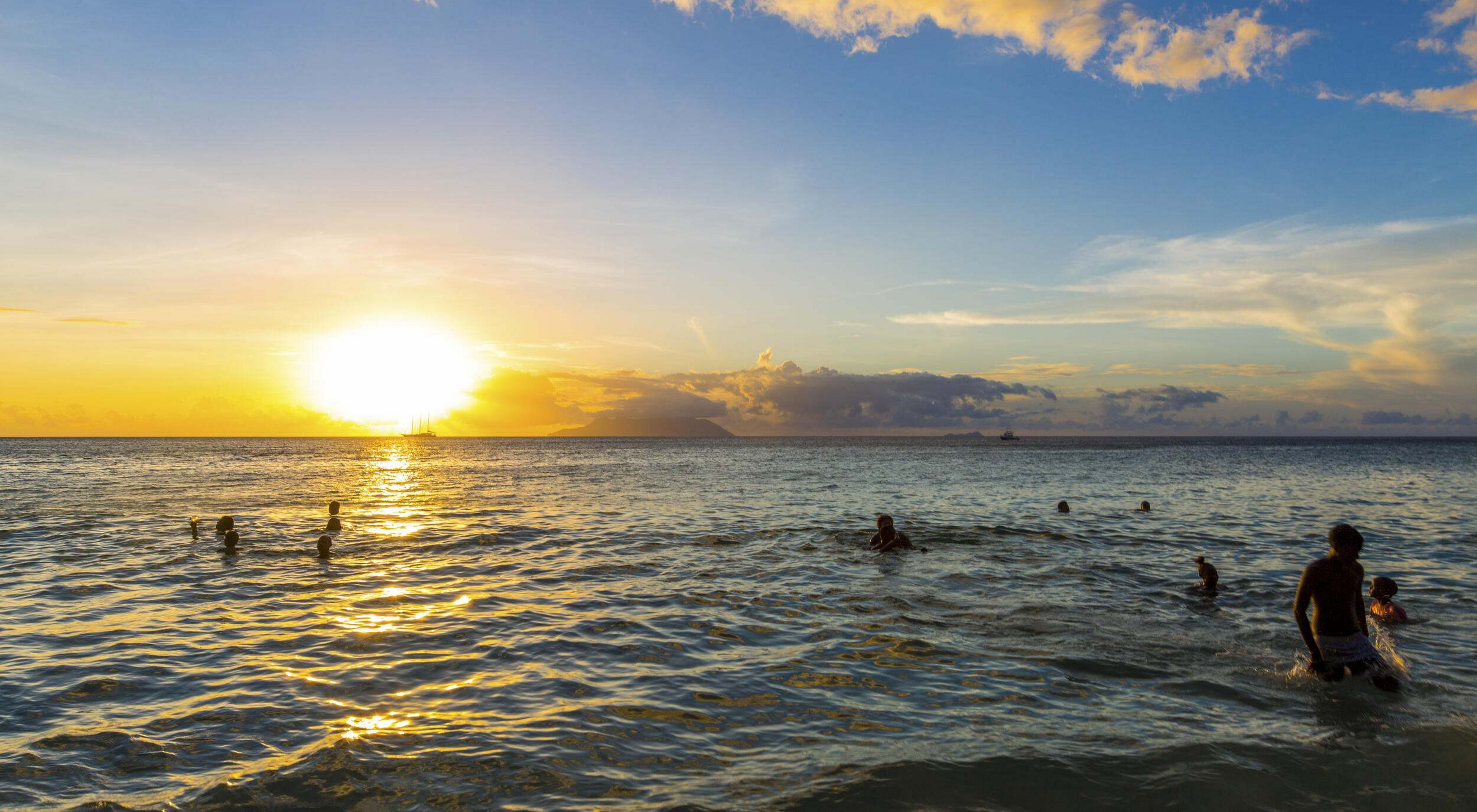 swimmers in the ocean at sunset 
