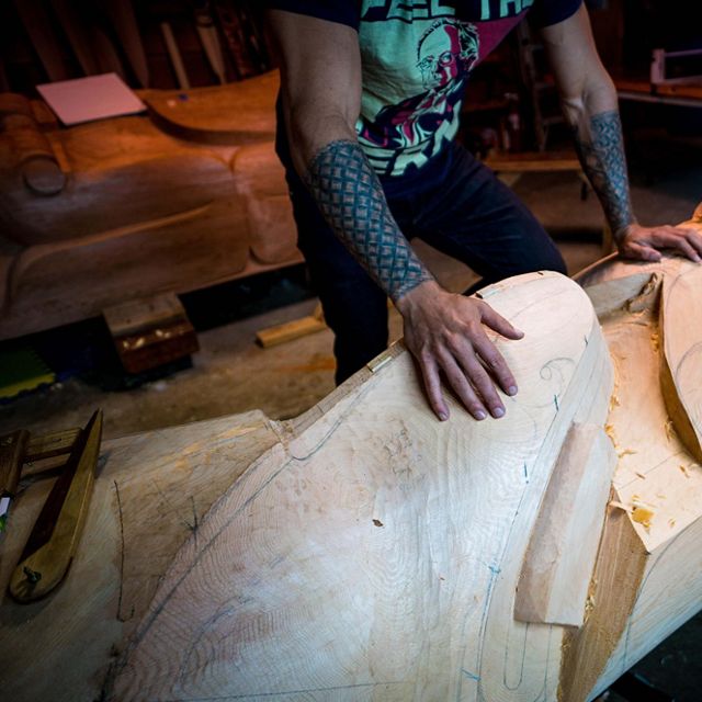 A man in the midst of carving a totem.