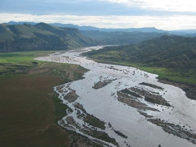 Ariel view of a river with mountains in the distance.