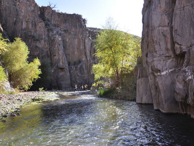 A river runs through a canyon. Hikers in the background.