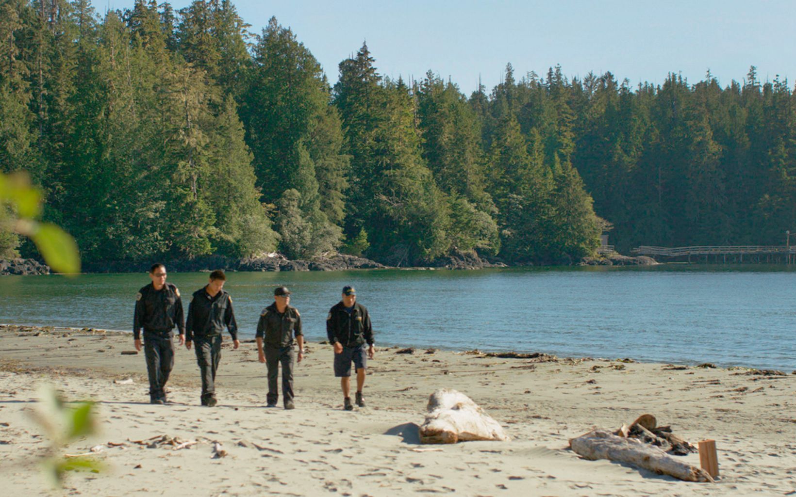 Across Canada, Indigenous guardian programs are essential for stewardship of land and water. Ahousaht Watchmen walk across beach in Canada.