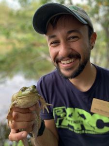Alex Navarro smiling and holding a frog.
