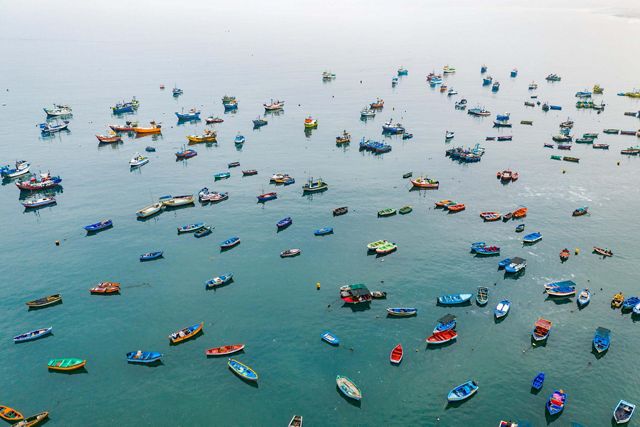 Colorful fishing boats fill a harbor in Ancón, Peru.