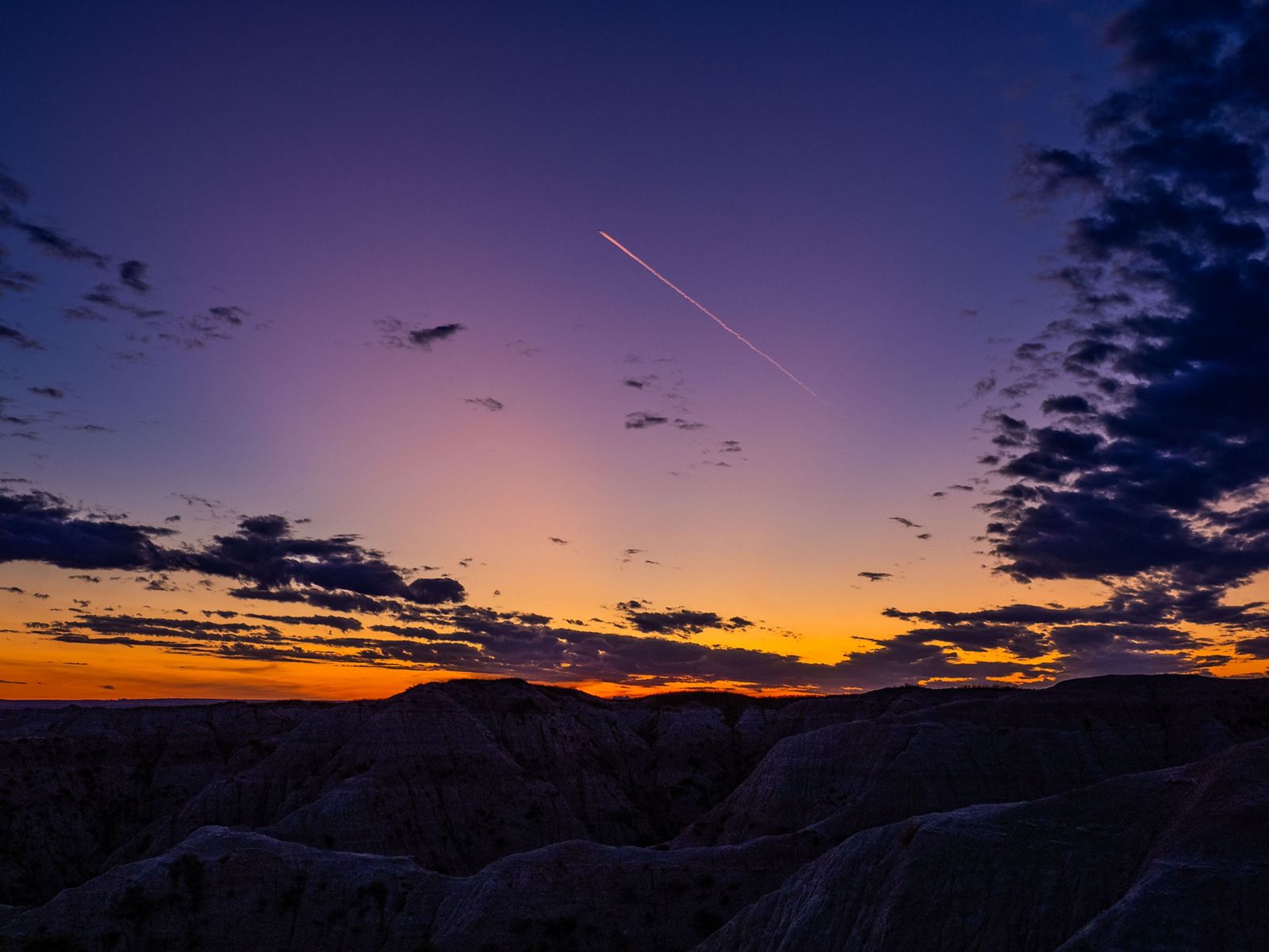 Jet trail at sunset in Badlands National Park, South Dakota.