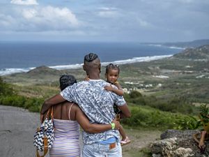 Family looks out over a bay in Barbados.