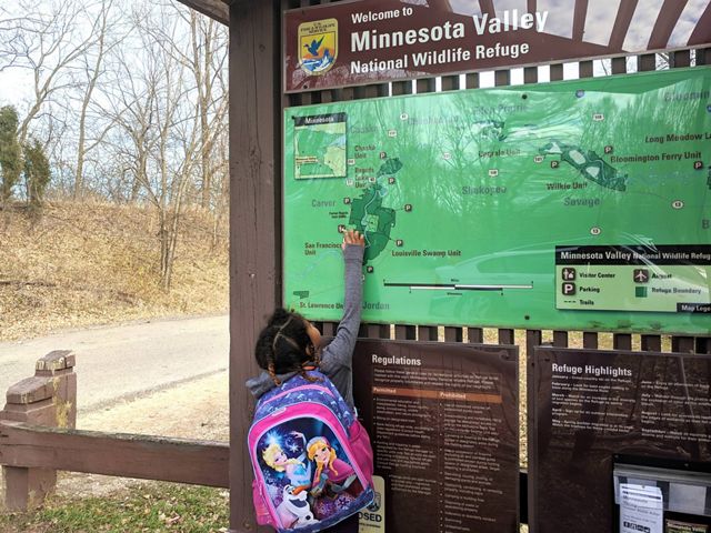 A small child points to a map at the Minnesota Valley National Wildlife Refuge