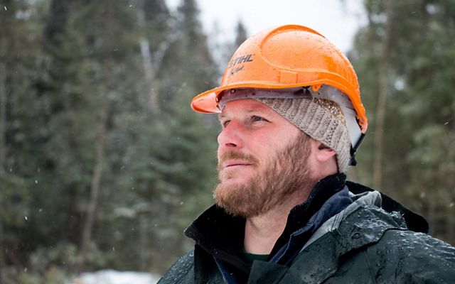 Conservation forester Chris Stone wears an orange hard hat.