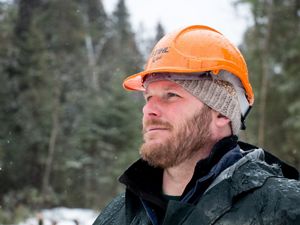 Close up of Chris Stone in the woods wearing his hard hat.