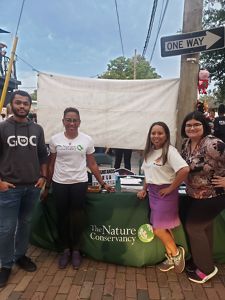A group of four people in front of an event table.