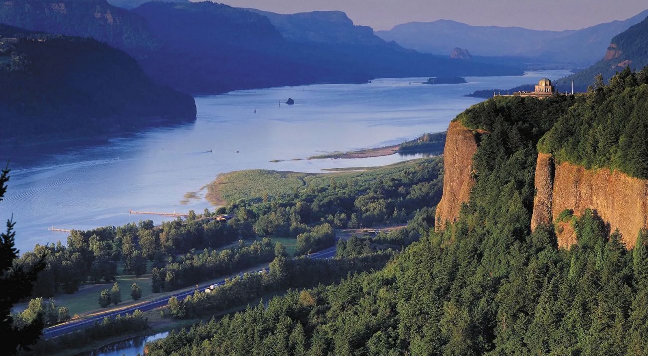 View from a high vantage point looking out at the Columbia River with high cliffs along its banks.