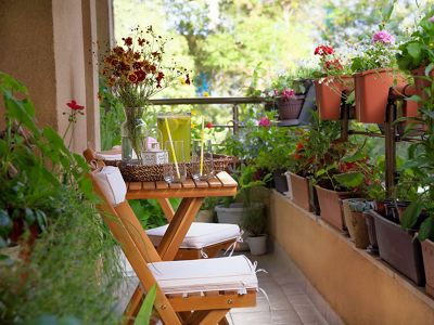 A balcony that has a lot of potted plants and flowers.