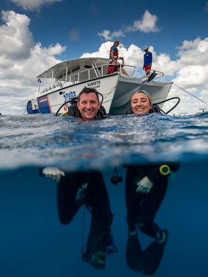 TNC staff members Joe Pollock and Ximena Escovar in the Caribbean Sea ready to dive and restore a coral reef.