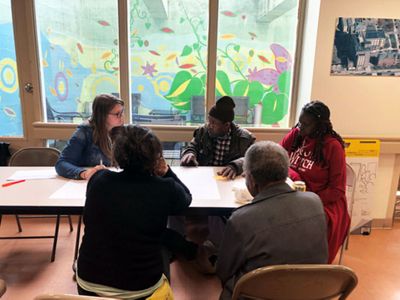 a group of community members sit around a table