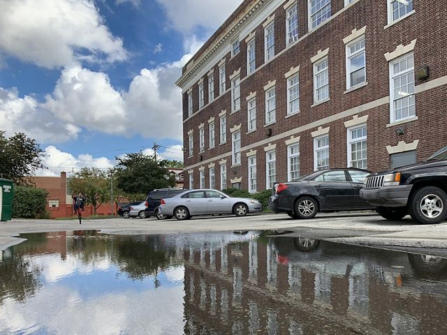 a large flood of water fills up a parking lot outside an apartment building