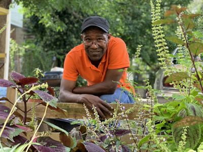 danyell brent is standing in front of the garden he tends to
