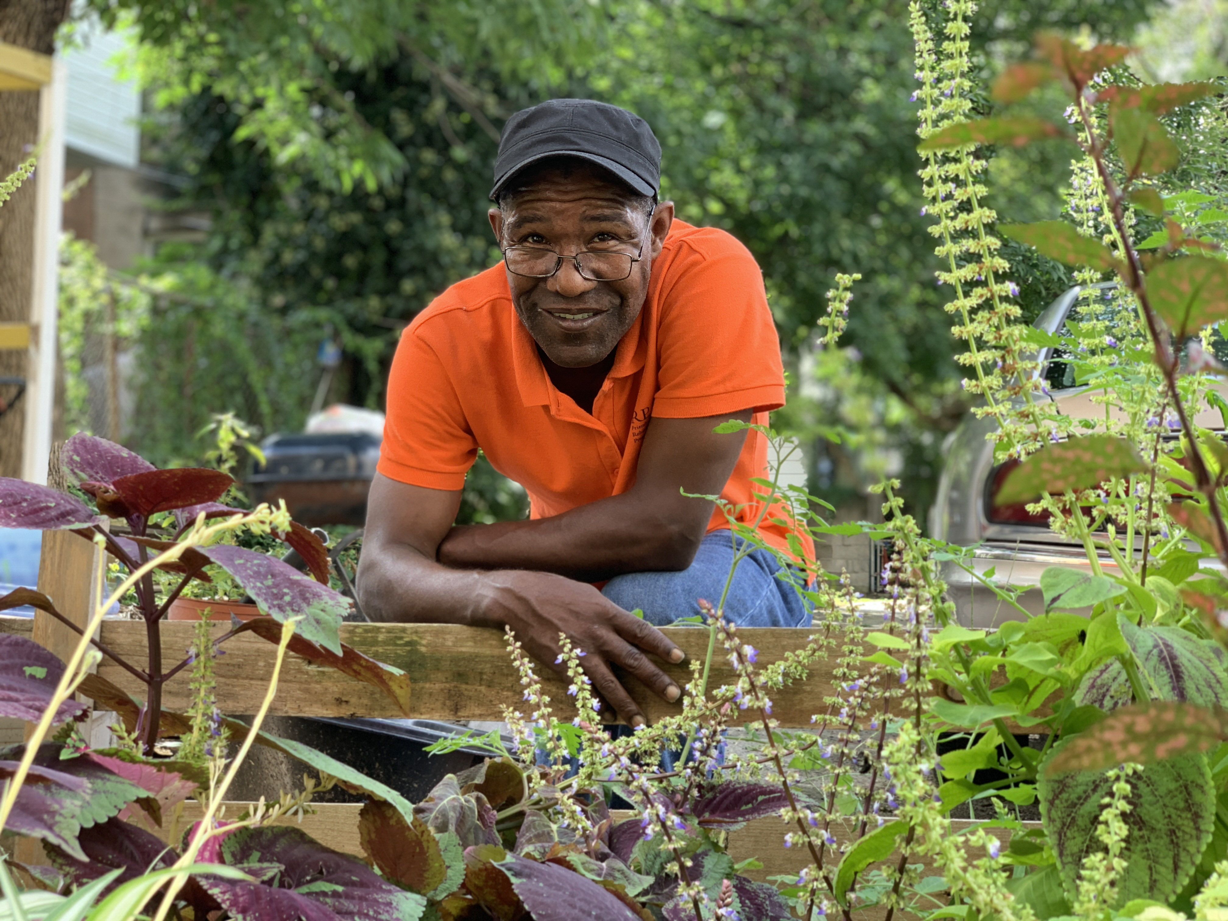 a man stands in front of a neighborhood garden